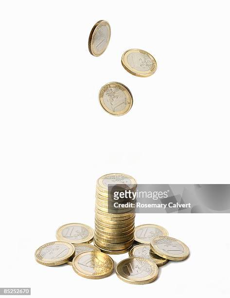 stack of one euro coins with coins falling above. - coins stockfoto's en -beelden