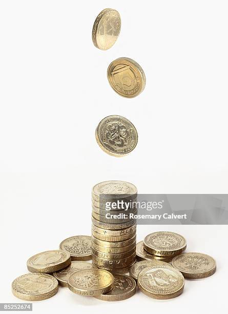 stack of one pound coins with pound coins falling  - british currency stockfoto's en -beelden