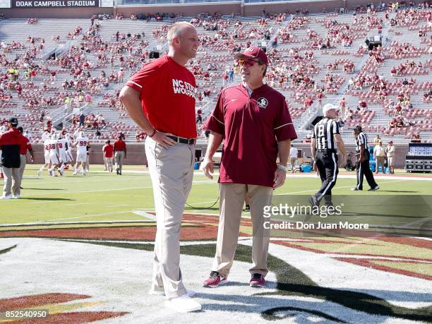Head Coaches Dave Doeren of the North Carolina State Wolfpack and Jimbo Fisher of the Florida State Seminoles talk at mid-field before their game at...