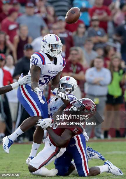 Teammates Aaron Roberson and Darryl Lewis of the Louisiana Tech Bulldogs break up a pass to Shi Smith of the South Carolina Gamecocks during their...