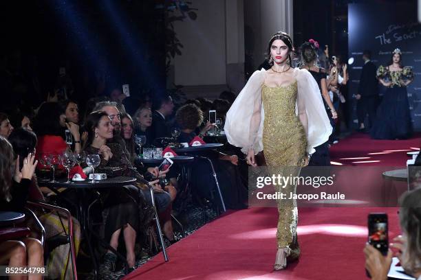 Model walks the runway at the Dolce & Gabbana secret show during Milan Fashion Week Spring/Summer 2018 at Bar Martini on September 23, 2017 in Milan,...