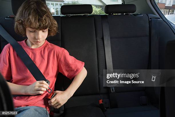 boy fastening his seatbelt - seatbelt stock pictures, royalty-free photos & images