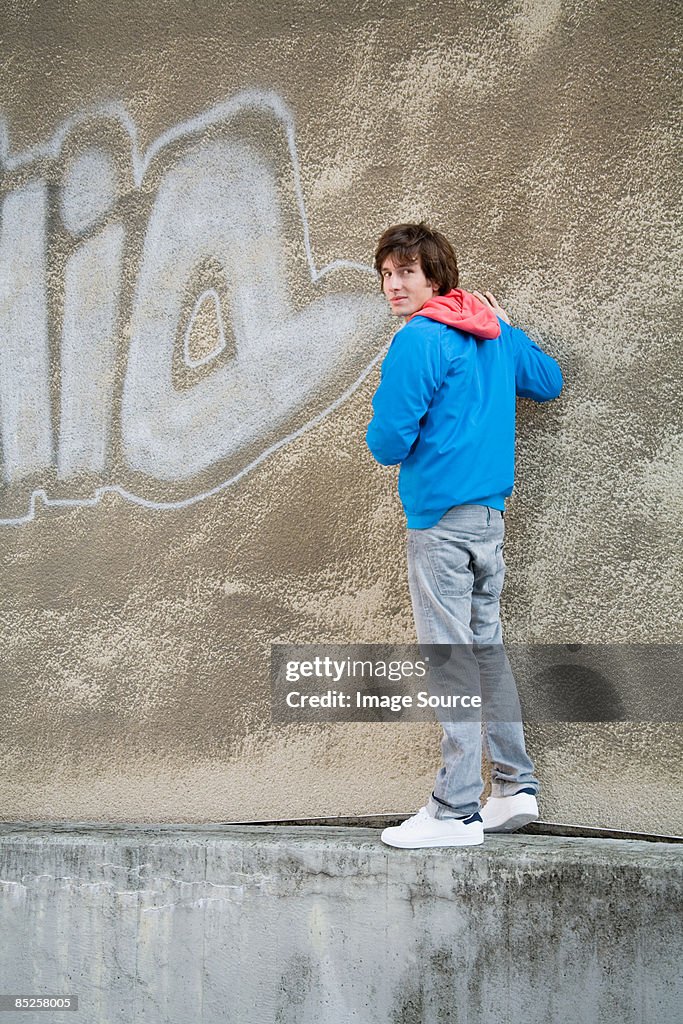 Young man standing on wall