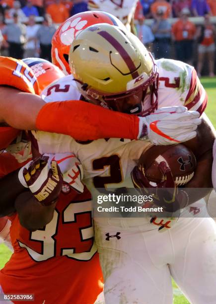 Running back AJ Dillon of the Boston College Eagles is brought down by defenders from the Clemson Tigers at Memorial Stadium on September 23, 2017 in...