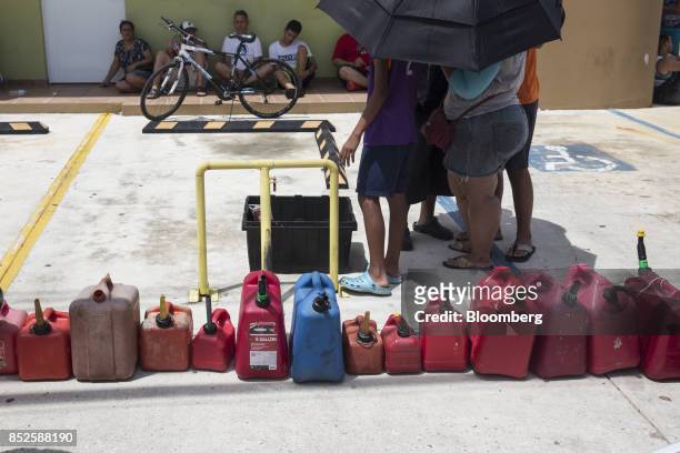 Residents wait for fuel with gas canisters after Hurricane Maria in Quebradillas, Puerto Rico, on Saturday, Sept. 23, 2017. Amid their struggles to...