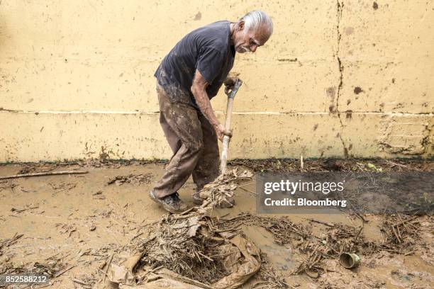 Resident shovels debris after Hurricane Maria in Arecibo, Puerto Rico, on Saturday, Sept. 23, 2017. Amid their struggles to recover...