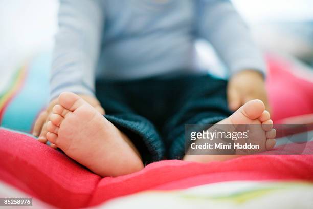 portrait of baby feet on colorful pillow - 4 months stock pictures, royalty-free photos & images