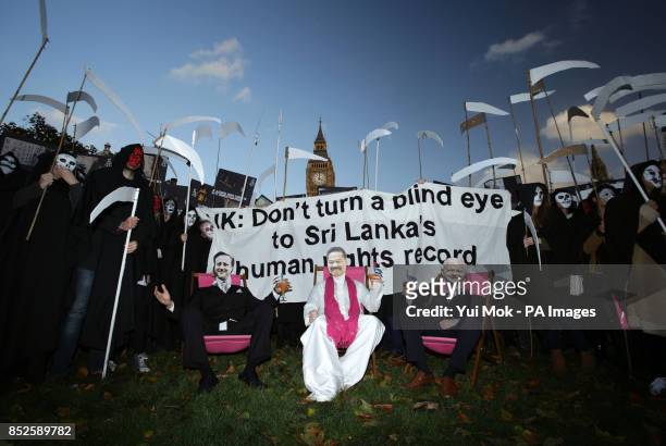 Amnesty supporters dressed as grim reapers, David Cameron, Sri Lankan president Mahinda Rajapaksa and Foreign Secretary William Hague, gather in...