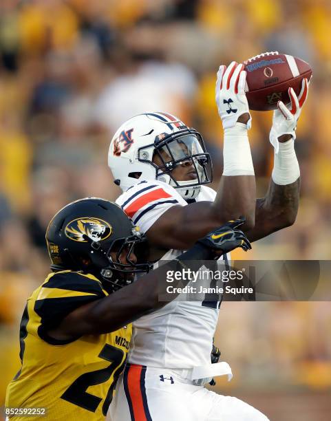 Wide receiver Kyle Davis of the Auburn Tigers makes a catch as defensive back Logan Cheadle of the Missouri Tigers defends during the game at Faurot...