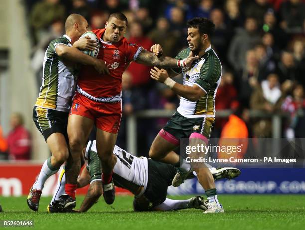 Tonga's Konrad Hurrell is tackled by Cook Island's Brad Takairangi , John Zebelon Peyroux and Issac John during the the 2013 World Cup match at Leigh...