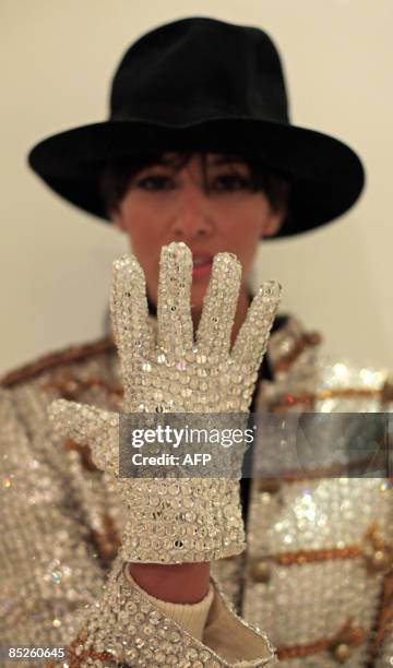 Model displays an iconic white-jewelled glove and a selection of onstage costumes, owned by US popstar Michael Jackson at the Museum of Style Icons...