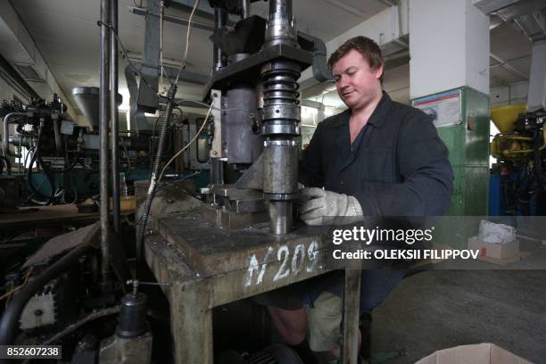 Picture taken on June 12, 2017 shows a partially sighted man working in a factory in Donetsk. The factory, which makes tin lids for jars and...