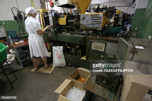 Picture taken on June 12, 2017 shows partially sighted woman making capsules for disposable shoe covers in a factory in Donetsk. The factory, which...