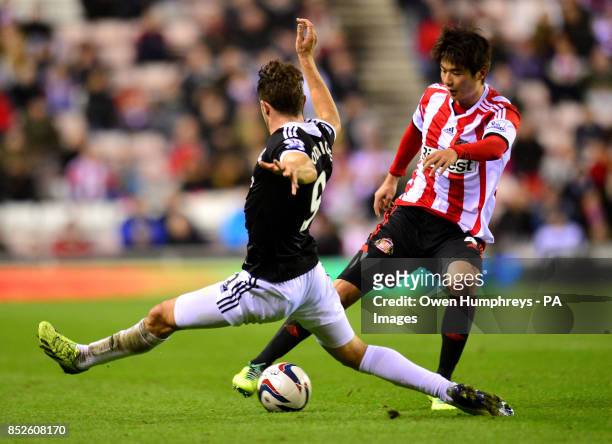 Sunderland's Ki Sung Yueng and Southampton's Jay Rodriguez in action during the Capital One Cup match at the Stadium of Light, Sunderland.