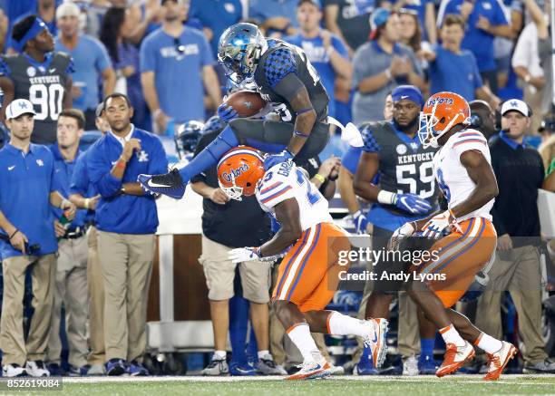 Benny Snell Jr#26 of the Kentucky Wildcats leaps over Chauncey Gardner Jr of the Florida Gators during the game at Kroger Field on September 23, 2017...