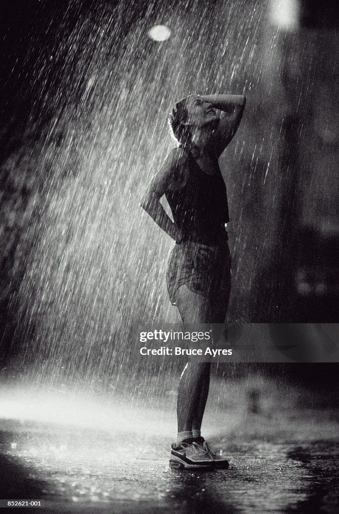 Female runner standing in pouring rain (B&W)