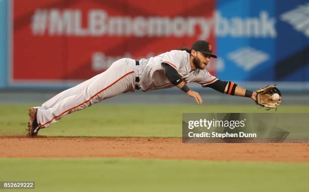 Shortstop Brandon Crawford of the San Francisco Giants dives to get a ground ball hit by Kike Hernandez of the Los Angeles Dodgers for the final out...