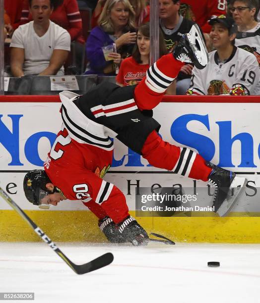 Brandon Saad of the Chicago Blackhawks is upended by Jacob Graves the Columbus Blue Jackets during a preseason game at the United Center on September...