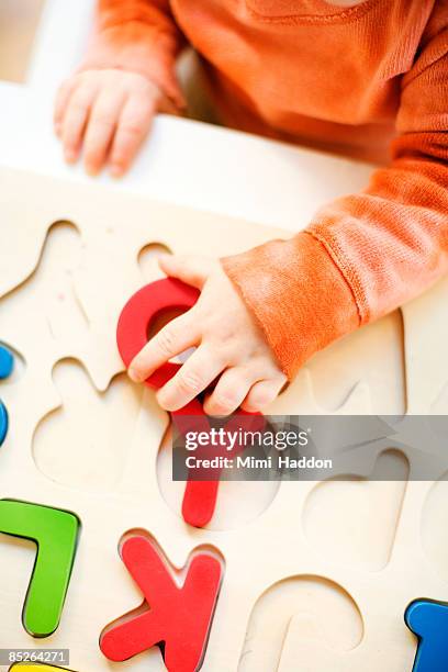 toddler boy playing with alphabet puzzle - playing puzzles stock pictures, royalty-free photos & images