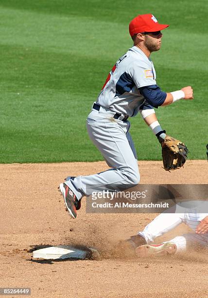 Infielder Dustin Pedroia of Team USA jumps over a sliding runner against the Philadelphia Phillies March 5, 2009 at Bright House Field in Dunedin,...