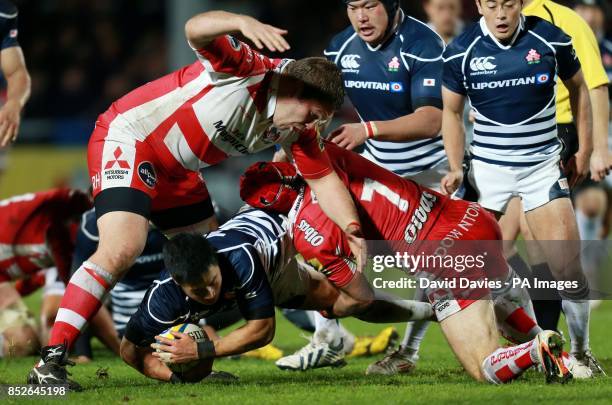 Japan's Akihito Yamada is tackled by Gloucester's Andy Hazell and Rupert Harden during an International Friendly at Kingsholm Stadium, Gloucester.