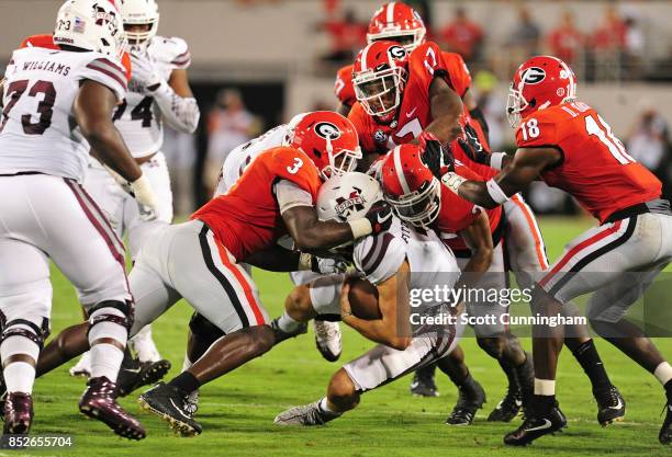 Nick Fitzgerald of the Mississippi State Bulldogs is tackled by Roquan Smith, Dominik Sanders, and Davin Bellamy of the Georgia Bulldogs at Sanford...