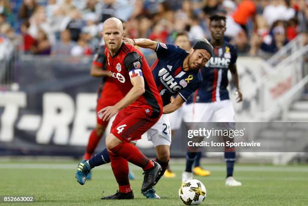 Toronto FC midfielder Michael Bradley takes the ball from New England Revolution midfielder Lee Nguyen during a match between the New England...