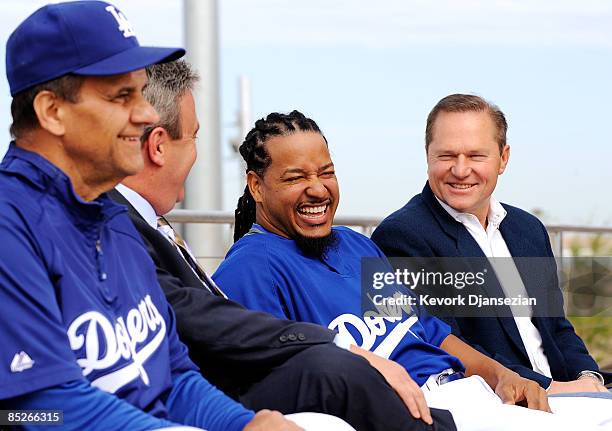 Manny Ramirez#99, second right, smiles as his Agent Scott Boras general manager Ned Colletti, second right, and manager Joe Torre look on during a...