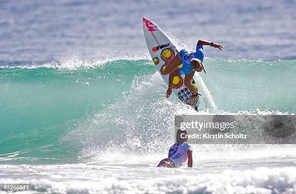 Page Hareb of New Zealand performs a backhand re-entry manouever as her opponent Amee Donohoe prepares to duck-dive under the wave during the Roxy...