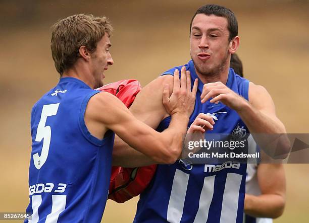 Todd Goldstein of the Kangaroos handballs under pressure from Sam Power during a Kangaroos AFL training session at Arden Street Oval March 6, 2009 in...