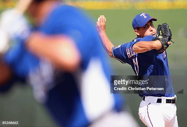 Relief pitcher Derek Holland of the Texas Rangers pitches against the Kansas City Royals during the spring training game at Surprise Stadium on March...