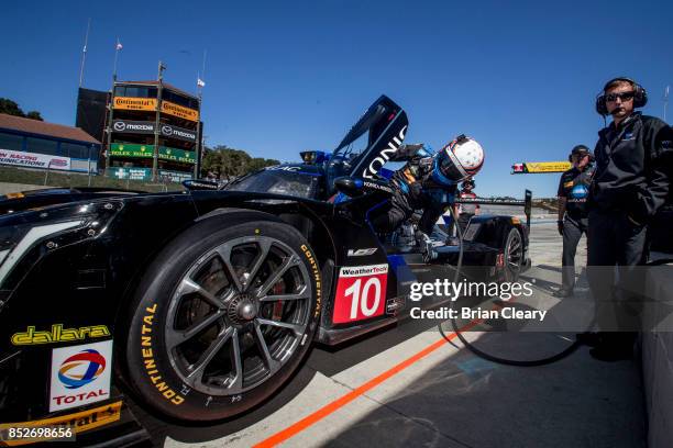 Ricky Taylor climbs from his race car after winning the pole position for the IMSA WeatherTech Sportscar Series race at Mazda Raceway Laguna Seca on...