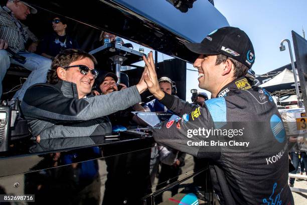 Ricky Taylor, R, high fives his father and car owner Wayne Taylor after winning the pole position for the IMSA WeatherTech Sportscar Series race at...