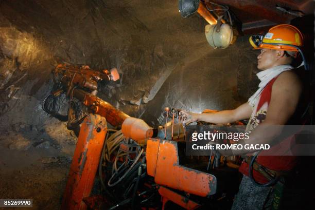 By Cecil Morella In this photo taken on May 27, 2006 shows a miner from Philex Mining Corp., using a drill machine before blasting to extract...