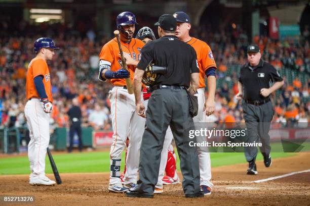 Houston Astros shortstop Marwin Gonzalez is hold back ny Houston Astros manager A.J. Hinch after being thrown out of the game after a third strike is...