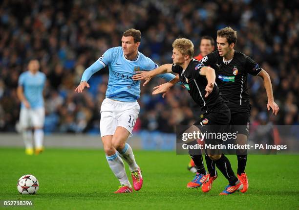 Manchester City's Edin Dzeko and Plzen's Tomas Horava and Vaclav Prochazka battle for the ball