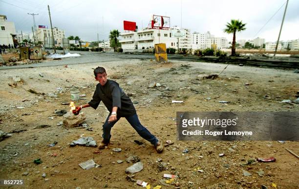 Young man throws a molotov cocktail at IDF jeeps October 20, 2000 as clashes continue with increased ferocity in Ramallah, on the West Bank. Israeli...