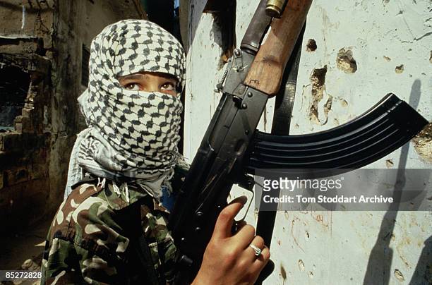 Young soldier with an assault rifle and a black and white keffiyeh in Beirut, during the Lebanese Civil War, circa 1989.