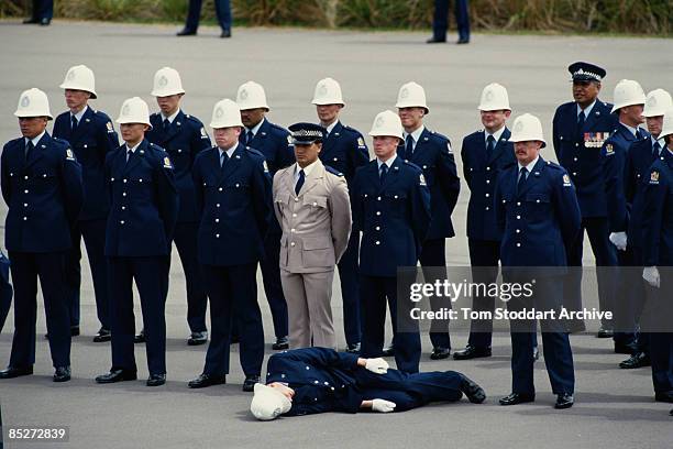 Trainee officer passes out during a parade at a police training school, part of the Queen's tour of New Zealand, February 1986.