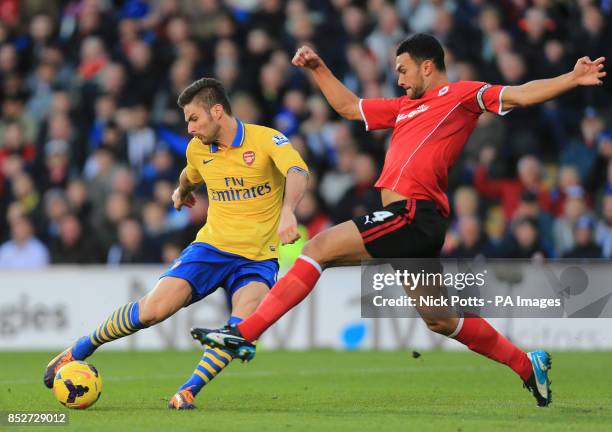 Arsenal's Olivier Giroud is challenge by Cardiff City captain Steven Caulker during the Barclays Premier League match at Cardiff City Stadium,...