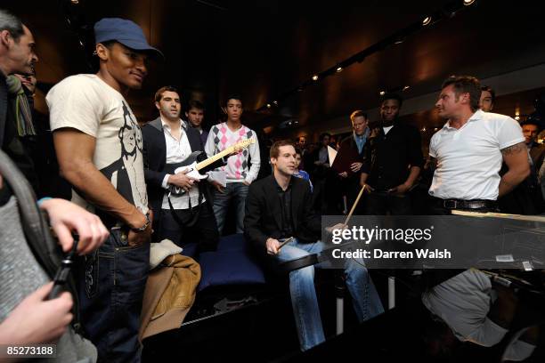 Petr Cech and Henrique Hilario play Rockstar and watched by the other players during the Chelsea FC and Armani charity party at The Armani Store,...