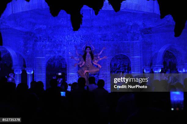 Indian devotees walk inside a 'pandal', a temporary worship place, for the upcoming festival 'Durga Puja', in Kolkata on September 24, 2017. The...