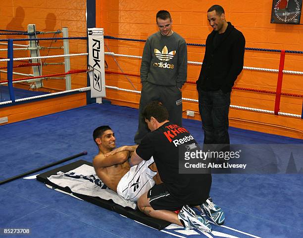 Frankie Gavin and James Degale watch Amir Khan during a media workout at the Gloves Community Centre on March 6, 2009 in Bolton, England. Amir Khan...