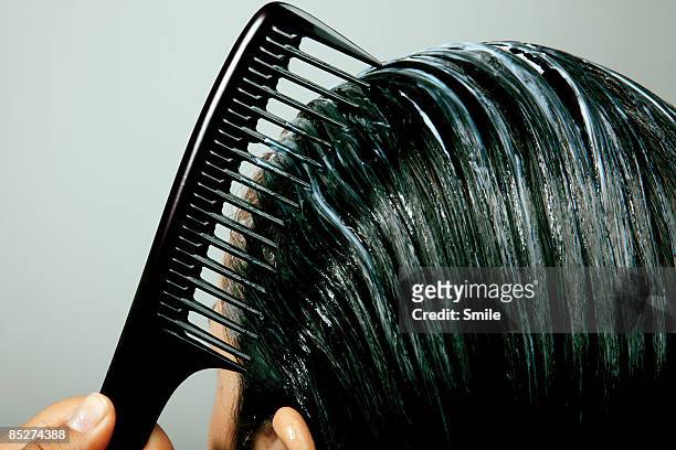 combing conditioner through hair, close up - peinar fotografías e imágenes de stock