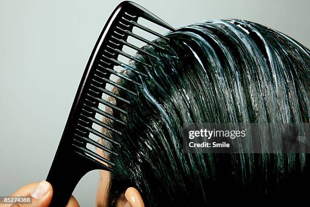 combing conditioner through hair, close up - pettine foto e immagini stock