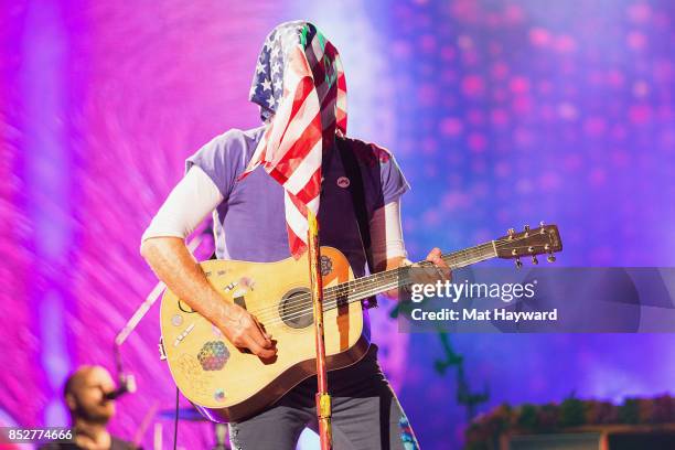 Chris Martin of Coldplay performs on stage with an American Flag over his face at CenturyLink Field on September 23, 2017 in Seattle, Washington.