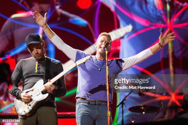 Jonny Buckland and Chris Martin of Coldplay performs on stage at CenturyLink Field on September 23, 2017 in Seattle, Washington.