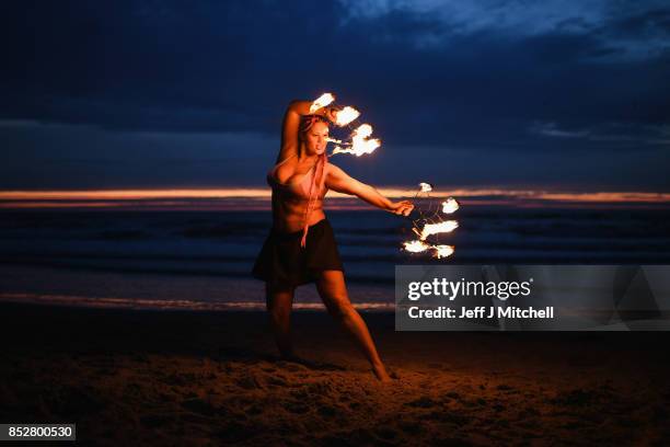 Penella Bee from Sunderland performs with fire before naked bathers enter the water during the North East Skinny Dip at Druridge bay on September 25,...