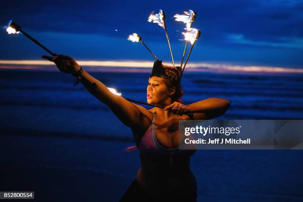 Penella Bee from Sunderland performs with fire before naked bathers enter the water during the North East Skinny Dip at Druridge bay on September 25,...