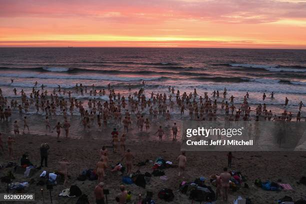 Naked bathers enter the water as they take part in the North East Skinny Dip at Druridge bay on September 25, 2017 in Druridge, England. The popular...